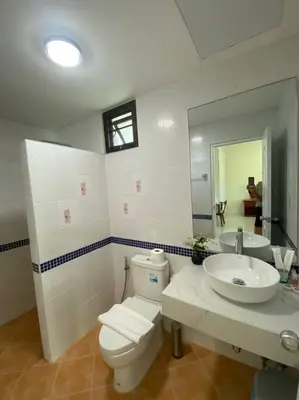 a bathroom with a toilet and a sink and a mirror at Kata beach townhouse in Kata Beach