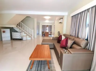 a living room with a couch and a coffee table at Kata beach townhouse in Kata Beach