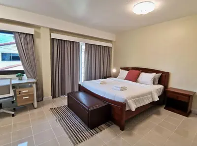 a bedroom with a bed and a desk and a television at Kata beach townhouse in Kata Beach
