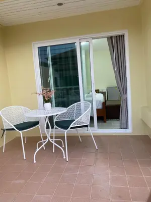 a patio with a table and chairs and a balcony at Kata beach townhouse in Kata Beach