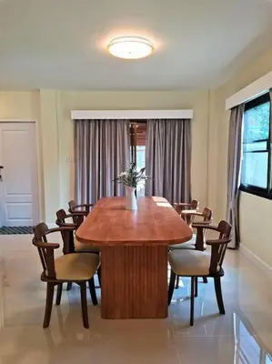 a dining room with a wooden table and chairs at Kata beach townhouse in Kata Beach