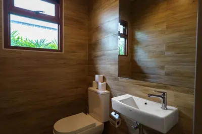 a bathroom with a toilet and a sink and a window at Blue Moon by G Estate Phuket in Ban Saiyuan (1)