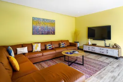 a living room with a couch and a flat screen tv at Blue Moon by G Estate Phuket in Ban Saiyuan (1)