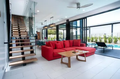a living room with a red couch and a table at LUXURY 4BR Oxygen Pool Villa Near Nai Harn Beach - Sunset Garden 7 in Rawai Beach