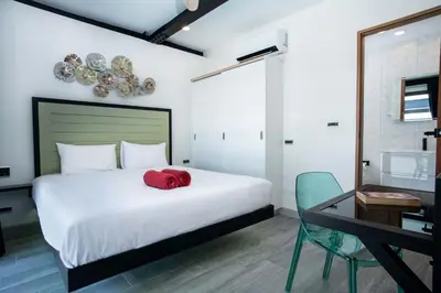 a bedroom with a bed with a red hat on it at LUXURY 4BR Oxygen Pool Villa Near Nai Harn Beach - Sunset Garden 7 in Rawai Beach