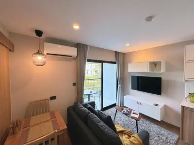 a living room with a couch and a table at The Title VH Rawai by Beringela in Phuket Town