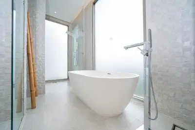 a white bath tub in a bathroom with a window at Andaman Villa 15 minutes from Bangtao Beach in Phuket Town