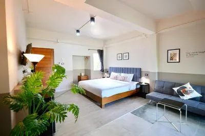 a bedroom with a bed and a couch at Alisse Stay Phuket Layan in Phuket Town