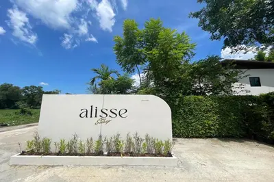 a sign for an alessasy sign on the side of a road at Alisse Stay Phuket Layan in Phuket Town