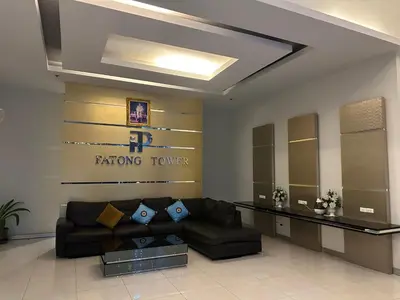 a living room with a couch and a sign on the wall at Patong tower 2bedroom 2 bathrooms, corner view in Patong Beach