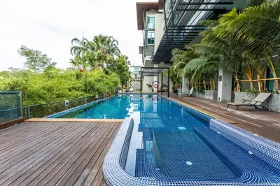 a swimming pool with a wooden deck and a building at C260 Beach And Town, Modern Big Apartment in Phuket Town