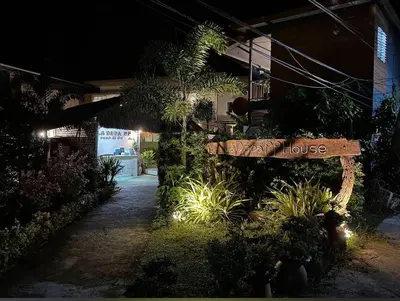 a sign for a house in a garden at night at La Depa PP House in Phi Phi Don