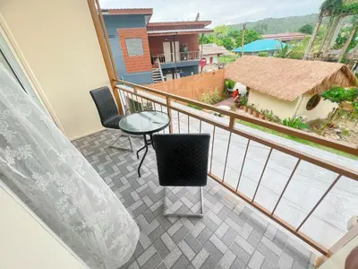 a balcony with a table and chairs and a view at La Depa PP House in Phi Phi Don