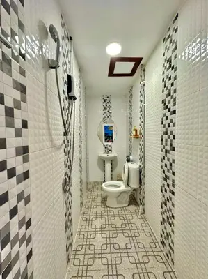 a bathroom with a toilet and a tiled floor at La Depa PP House in Phi Phi Don