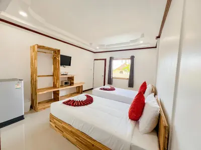 a bedroom with two beds with red pillows at La Depa PP House in Phi Phi Don