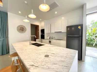 a kitchen with a marble counter top and a refrigerator at 3 Bed Bang Tao pool villa at The Lux in Phuket Town