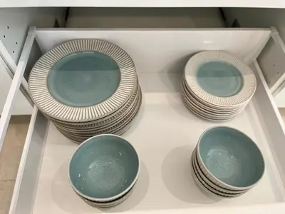 four plates and bowls on a shelf in a drawer at 3 Bed Bang Tao pool villa at The Lux in Phuket Town