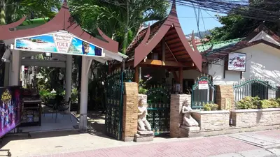 a building with a gate and a fence at Baan Orchid Guesthouse in Patong Beach