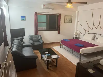 a living room with a bed and a couch at Baan Orchid Guesthouse in Patong Beach