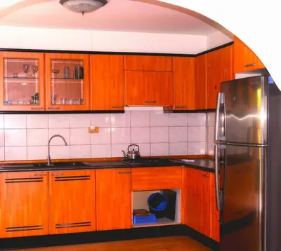 a kitchen with wooden cabinets and a stainless steel refrigerator at Baan Orchid Guesthouse in Patong Beach