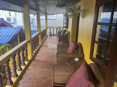 a balcony of a house with wicker chairs at Baan Orchid Guesthouse in Patong Beach