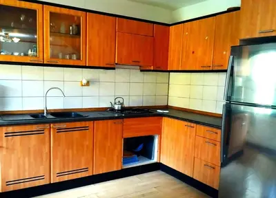 a kitchen with wooden cabinets and a sink and a refrigerator at Baan Orchid Guesthouse in Patong Beach