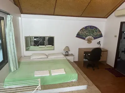 a bedroom with a green bed and a desk at Baan Orchid Guesthouse in Patong Beach