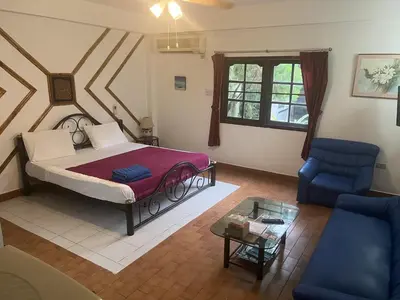 a bedroom with a bed and a couch and a table at Baan Orchid Guesthouse in Patong Beach