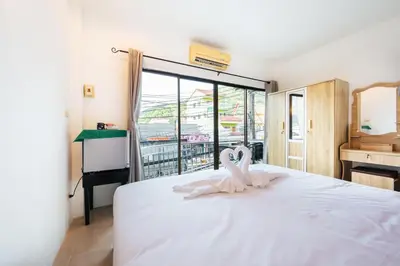 a bedroom with a white bed with a heart decoration on it at Fora Boutique Hotel in Karon Beach