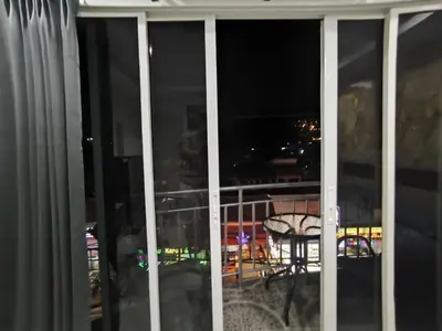 a view from a window of a balcony at night at Fora Boutique Hotel in Karon Beach