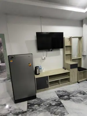 a refrigerator in a room with a flat screen tv at Fora Boutique Hotel in Karon Beach