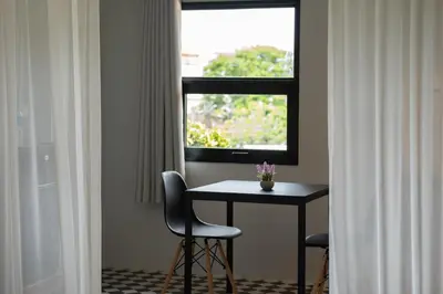 a table and chairs in a room with a window at Baan Old Town Boutique Stay, Phuket Town in Phuket Town