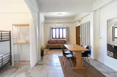 a dining room with a table and chairs and a couch at Baan Old Town Boutique Stay, Phuket Town in Phuket Town