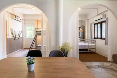 a dining room with a table and a bedroom at Baan Old Town Boutique Stay, Phuket Town in Phuket Town