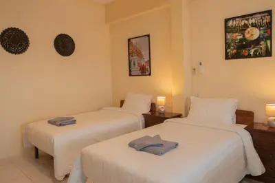 two beds in a hotel room with towels on them at Maiiam Guesthouse Patong in Patong Beach