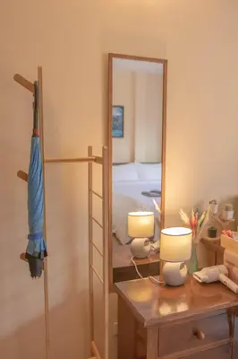 a bedroom with a bed and a mirror and a desk at Maiiam Guesthouse Patong in Patong Beach