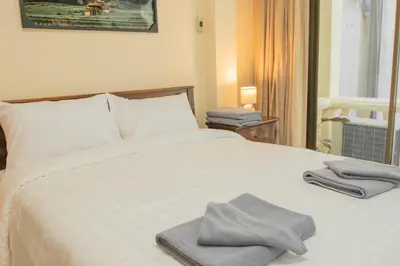 a bed with two towels sitting on top of it at Maiiam Guesthouse Patong in Patong Beach