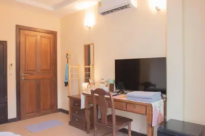 a room with a desk with a computer and a television at Maiiam Guesthouse Patong in Patong Beach
