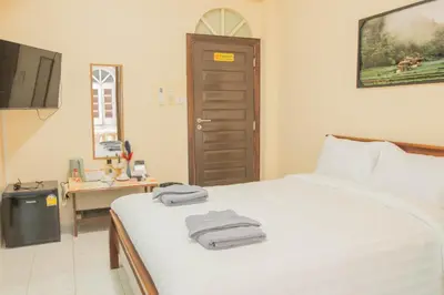 a bedroom with a bed with towels on it at Maiiam Guesthouse Patong in Patong Beach