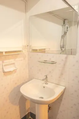 a bathroom with a sink and a mirror at Maiiam Guesthouse Patong in Patong Beach