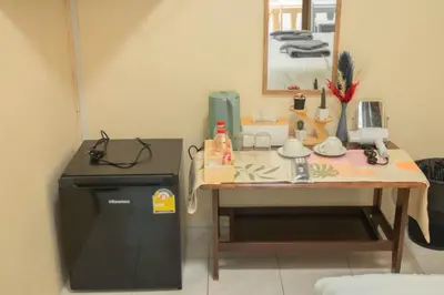 a room with a table with a counter and a small refrigerator at Maiiam Guesthouse Patong in Patong Beach