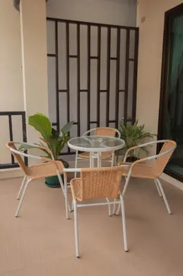 a glass table and chairs on a balcony at Maiiam Guesthouse Patong in Patong Beach