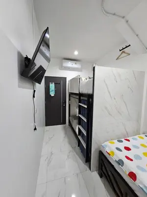 a bedroom with a bed and a tv on a wall at Haru Inn Airport in Ban Bo Han