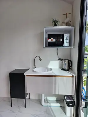 a bathroom with a sink and a microwave at Haru Inn Airport in Ban Bo Han