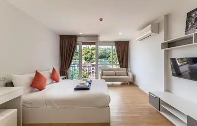 a bedroom with a bed and a living room at Ozone Phuket Kata Beach Resort & Wellness in Kata Beach