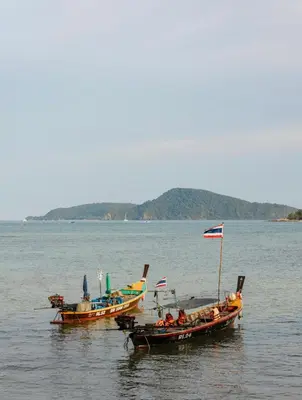 two boats in the water with people in them at Ozone Phuket Kata Beach Resort & Wellness in Kata Beach