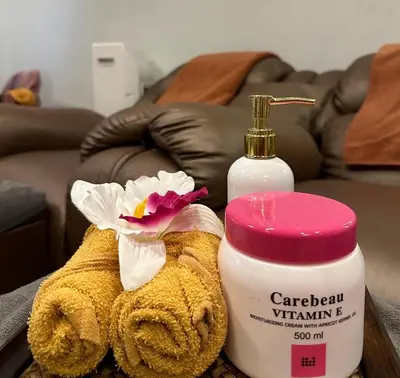 a bottle of caribbean vitamin k next to a towel and a flower at Ozone Phuket Kata Beach Resort & Wellness in Kata Beach