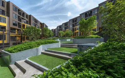 a courtyard with some grass and some buildings at THE BASE CENTRAL Phuket Shopping Mall Central Floresta in Ban Rangeng
