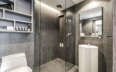 a bathroom with a toilet and a glass shower at Citygate Kamala Resort & Residence in Kamala Beach