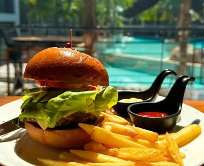 a hamburger and french fries on a plate with ketchup at Citygate Kamala Resort & Residence in Kamala Beach